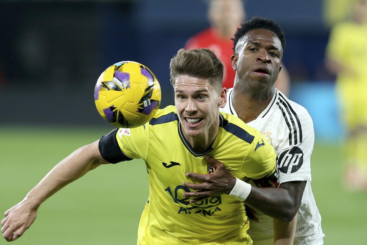 Real Madrid's Vinicius Junior vies for the ball with Villarreal's Juan Foyth, left, during a Spanish La Liga soccer match between Villarreal and Real Madrid in Villarreal, Spain, Saturday, March 15, 2025. (AP Photo/Alberto Saiz)