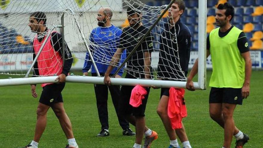 Los jugadores granates trasladan una portería en Pasarón antes de un entrenamiento. // Rafa Vázquez