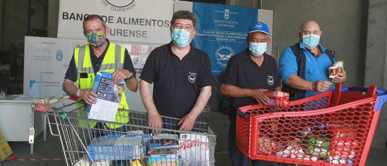 Colaboradores del banco de alimentos de Ourense, con dos carros de productos para personas necesitadas. // IÑAKI OSORIO