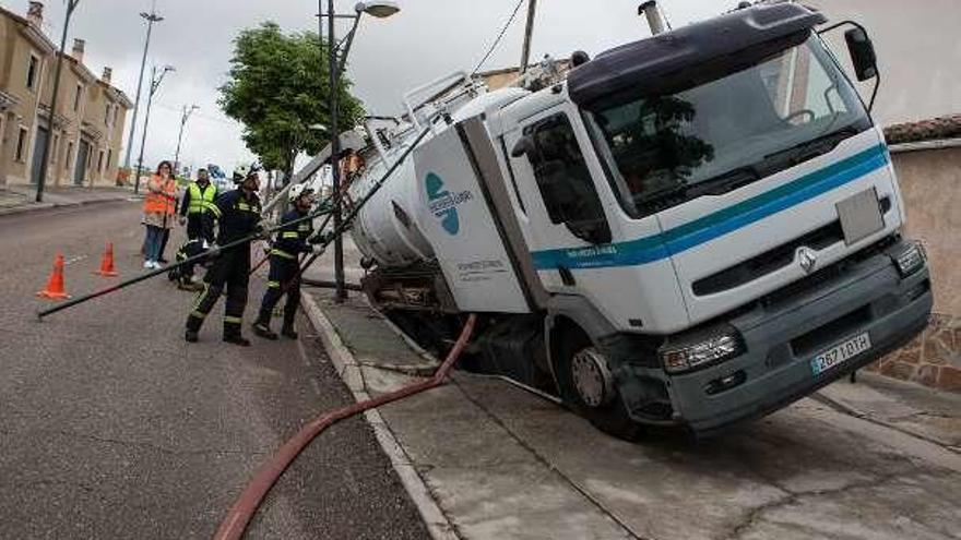 Un camión de saneamiento, atrapado en un socavón