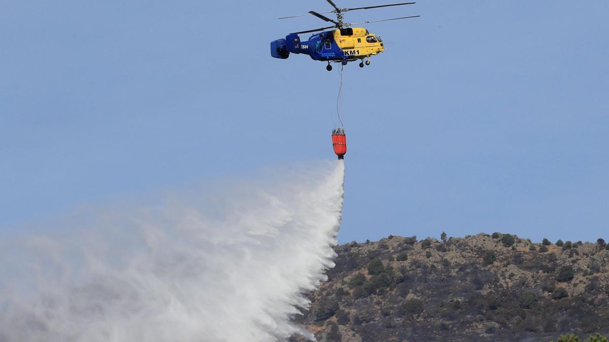 Un helicóptero trabaja apagando un fuego