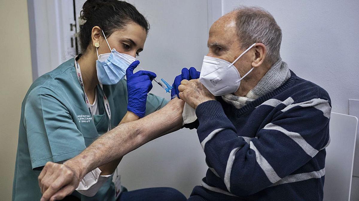 Una enfermera vacuna a una persona mayor de 80 años en un centro de salud de València.  | JM LÓPEZ
