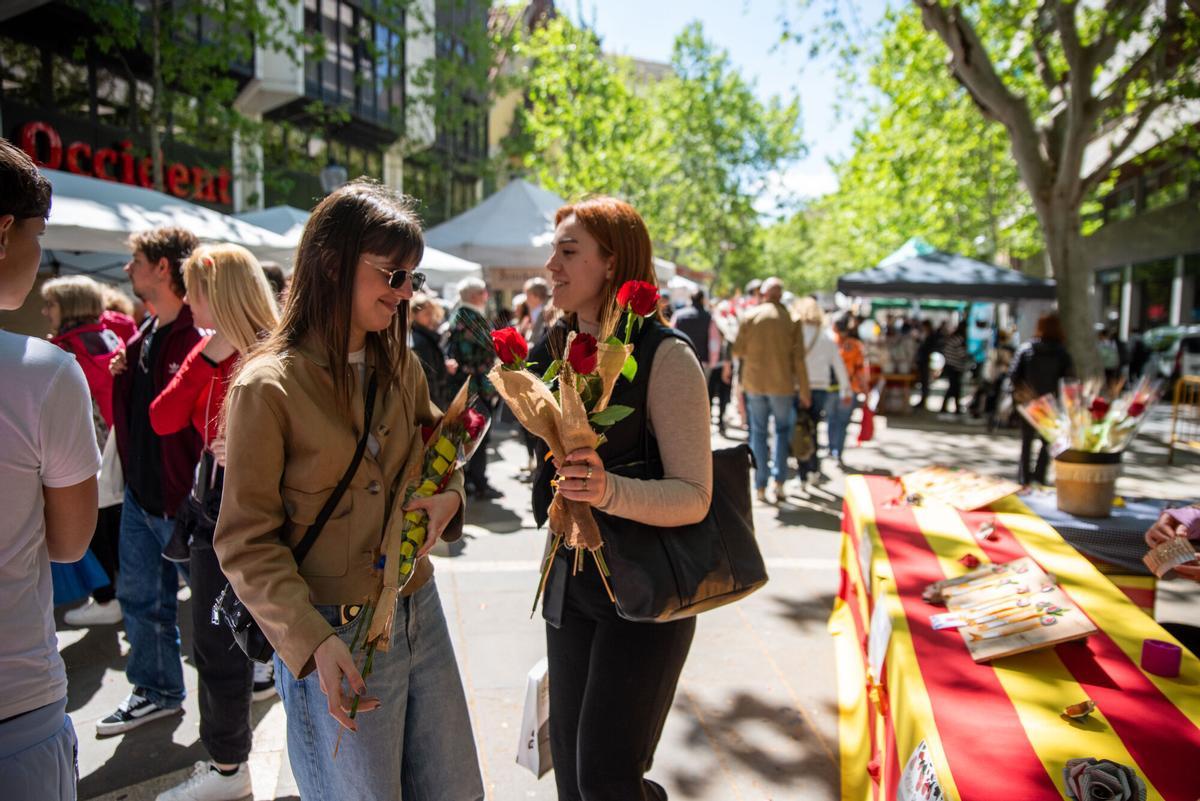 Dues noies a les parades instal·lades al passeig de Manresa durant la Diada de Sant Jordi 2025