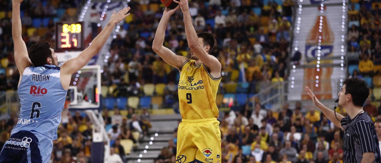 Nico Brussino ejecuta un lanzamiento mientras es defendido por Rudan.