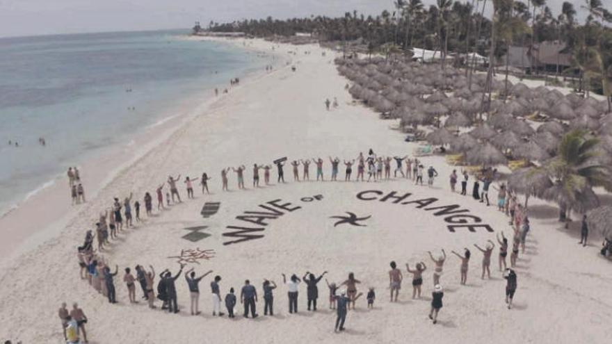 Turistas formando un círculo reivindicativo en una playa del Caribe.