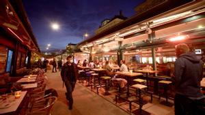 People share time at a cafe bar at Naschmarkt market the evening before the start of the second lockdown amid the coronavirus di