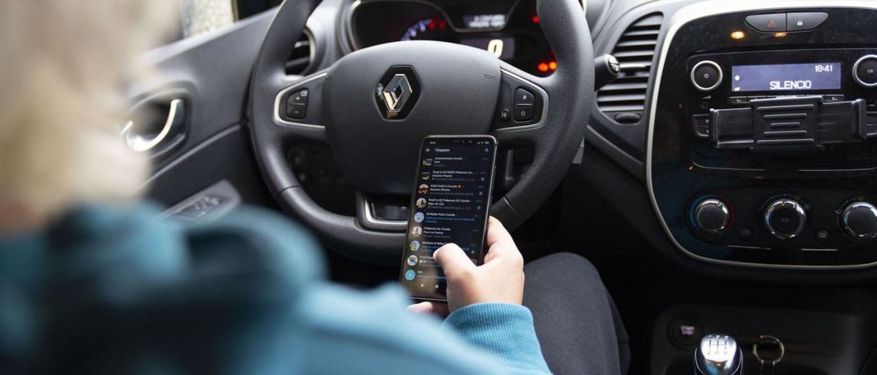 Una persona manipula el teléfono móvil mientras conduce. |   // ROLLER AGENCIA
