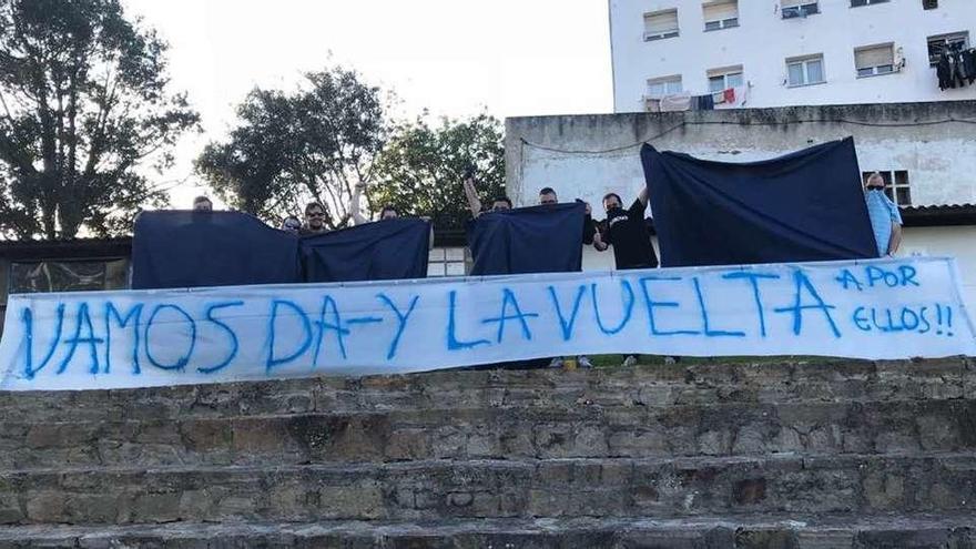 Aficionados del Marino de Luanco colocan una pancarta en las gradas de Miramar para el partido de vuelta contra el San Fernando.