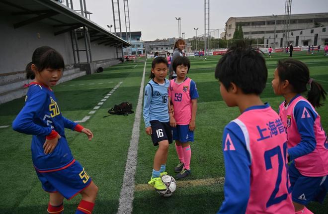 Las niñas juegan al fútbol durante una sesión de entrenamiento en su escuela en Shanghai.