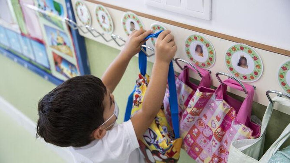 Un niño cuelga su mochila al llegar al colegio.