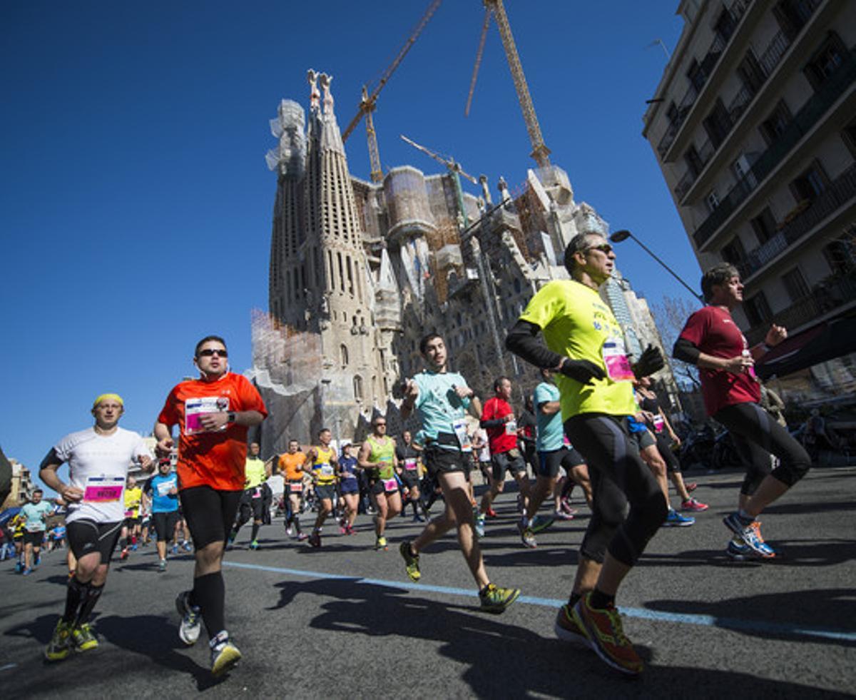 Els corredors, al seu pas per la Sagrada Família en el km 17 del recorregut de la Marató de Barcelona.