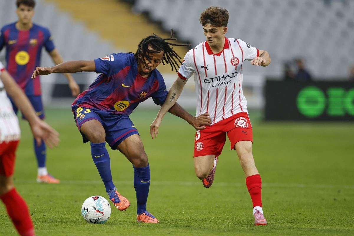 BARCELONA, 18/10/2025.- El defensa del FC Barcelona Jules Kounde (i) pelea una posesión con el delantero del Girona Joel Roca durante el partido de la jornada 9 de LaLiga EA Sports, entre el FC Barcelona y el Girona FC, en el estadio Olímpico de Montjuic, en Barcelona. EFE/ Alejandro García