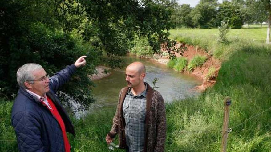 Francisco Santianes y Jorge Espina observan el cauce del Piles a su paso por Viesques, con tierra removida al fondo.