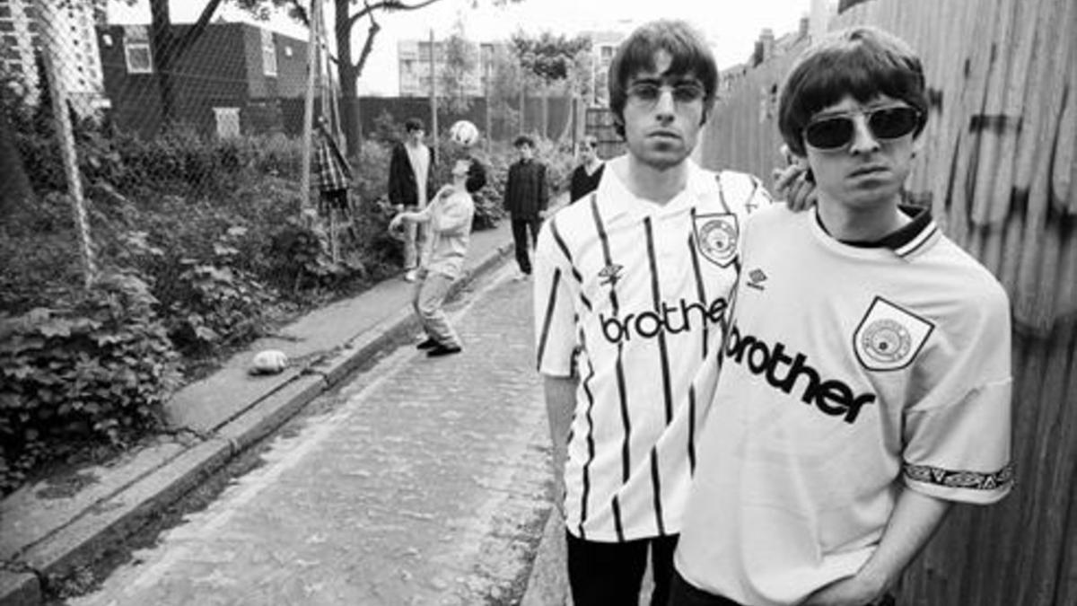 Liam y Noel Gallagher (derecha), y el resto de Oasis (al fondo), en 'Supersonic'.