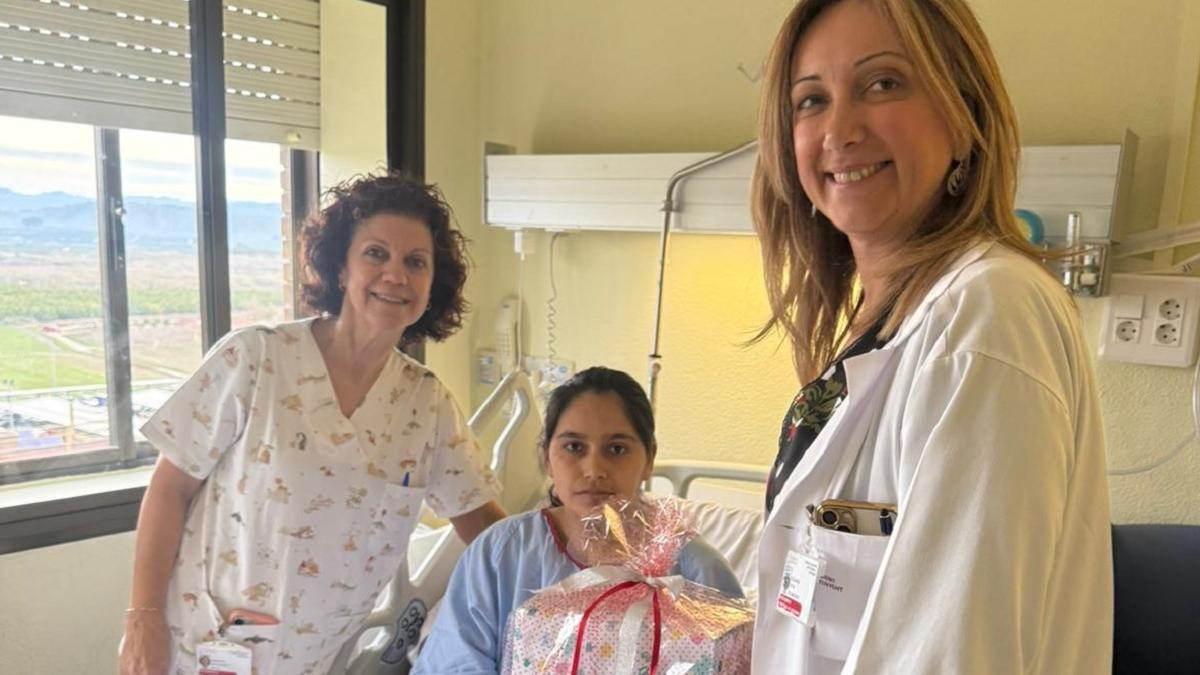 La directora de Enfermería y la responsable de planta entregan un obsequio a la madre de Milagros.