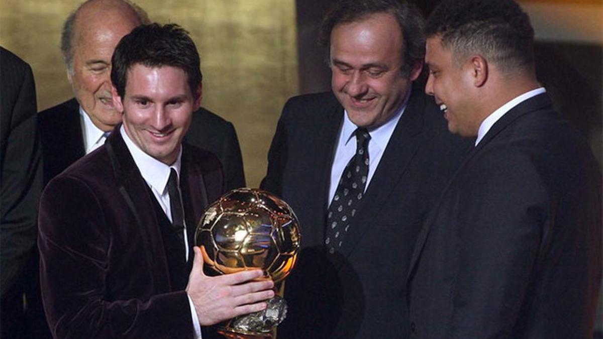 Leo Messi recibiendo de Ronaldo Nazario su tercer galardón en presencia de Michel Platini