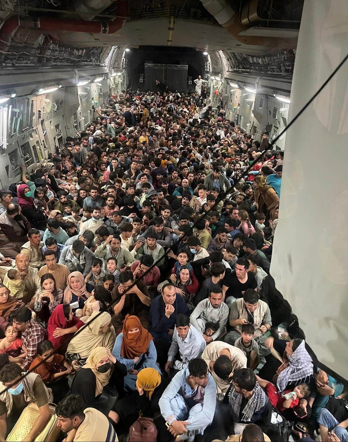 17/8/2021. Decenas de refugiados afganos viajan en un avión de carga estadounidense huyendo del régimen talibán, tras recuperar los radicales el poder en el país.