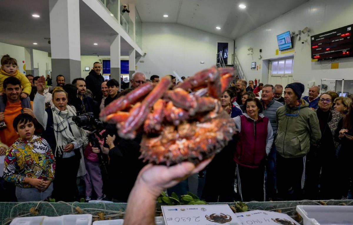 Momento en el que Tania Chao, con la mano en alto,
ofrece en la lonja 390 euros por la mejor
centolla de O Grove.  |  Iñaki Abella