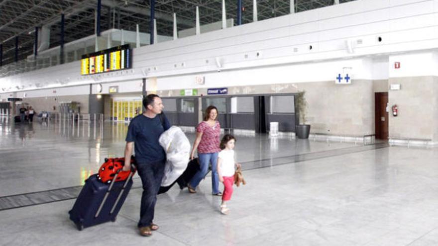 Una familia de turistas pasa por delante de las dependencias médicas en el aeropuerto insular, ayer. | fuselli