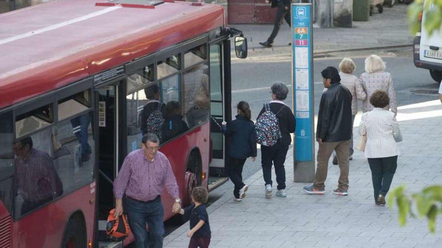 Vecinos se suben al bus en la plaza de España.