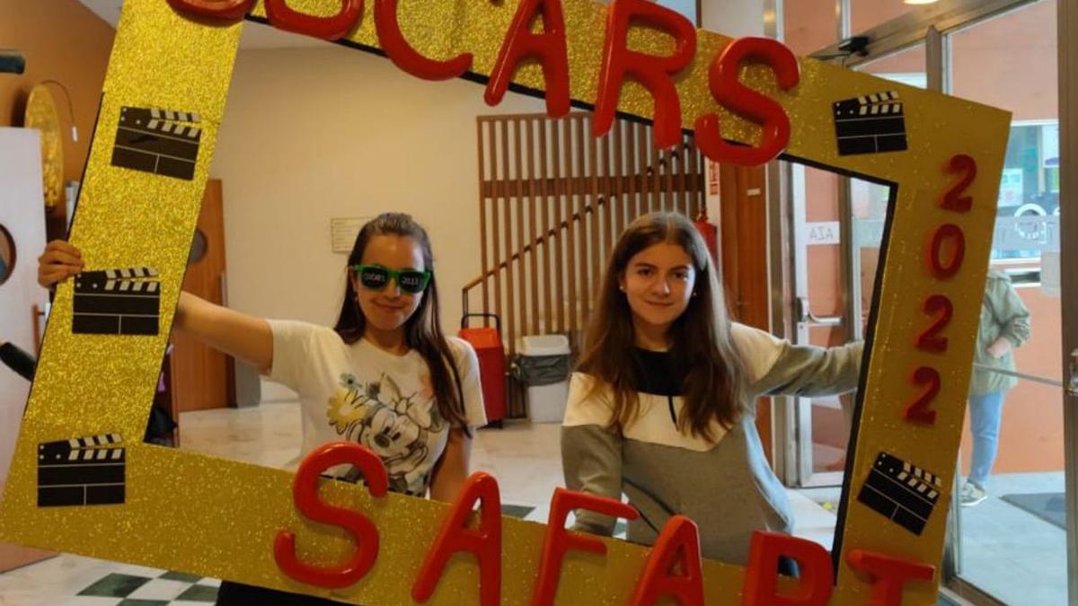 Dos alumnas del centro educativo, con el marco de la ceremonia.