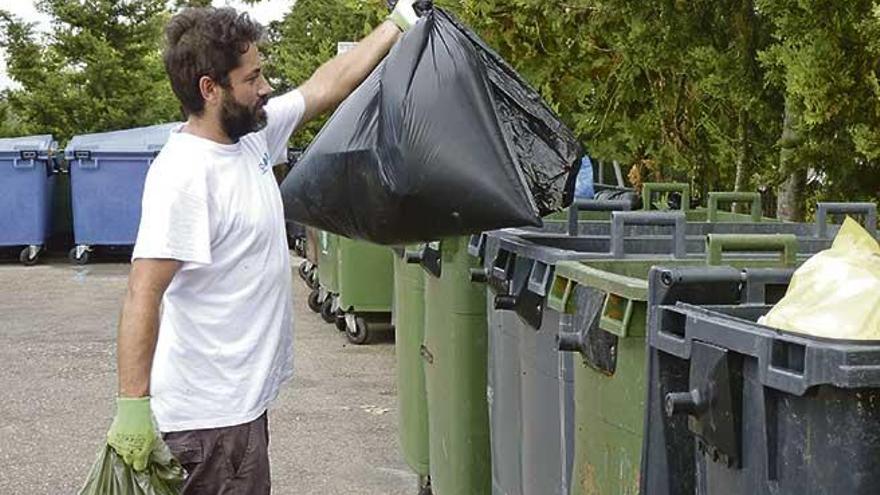 Un hombre lanza sus bolsas de basura en el Punt Verd.