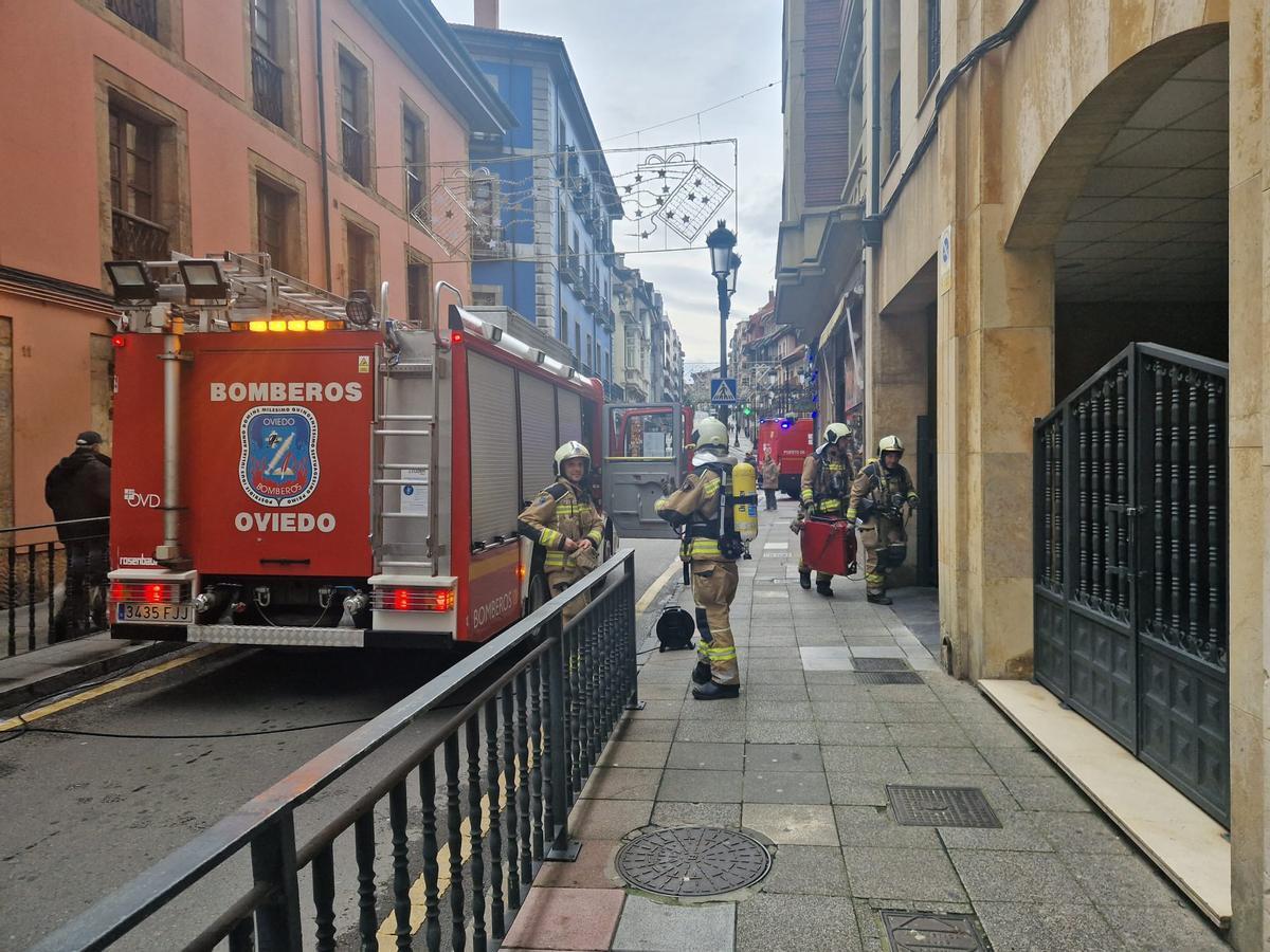 Los bomberos accediendo al portal al que se le incendió el cuadro eléctrico.