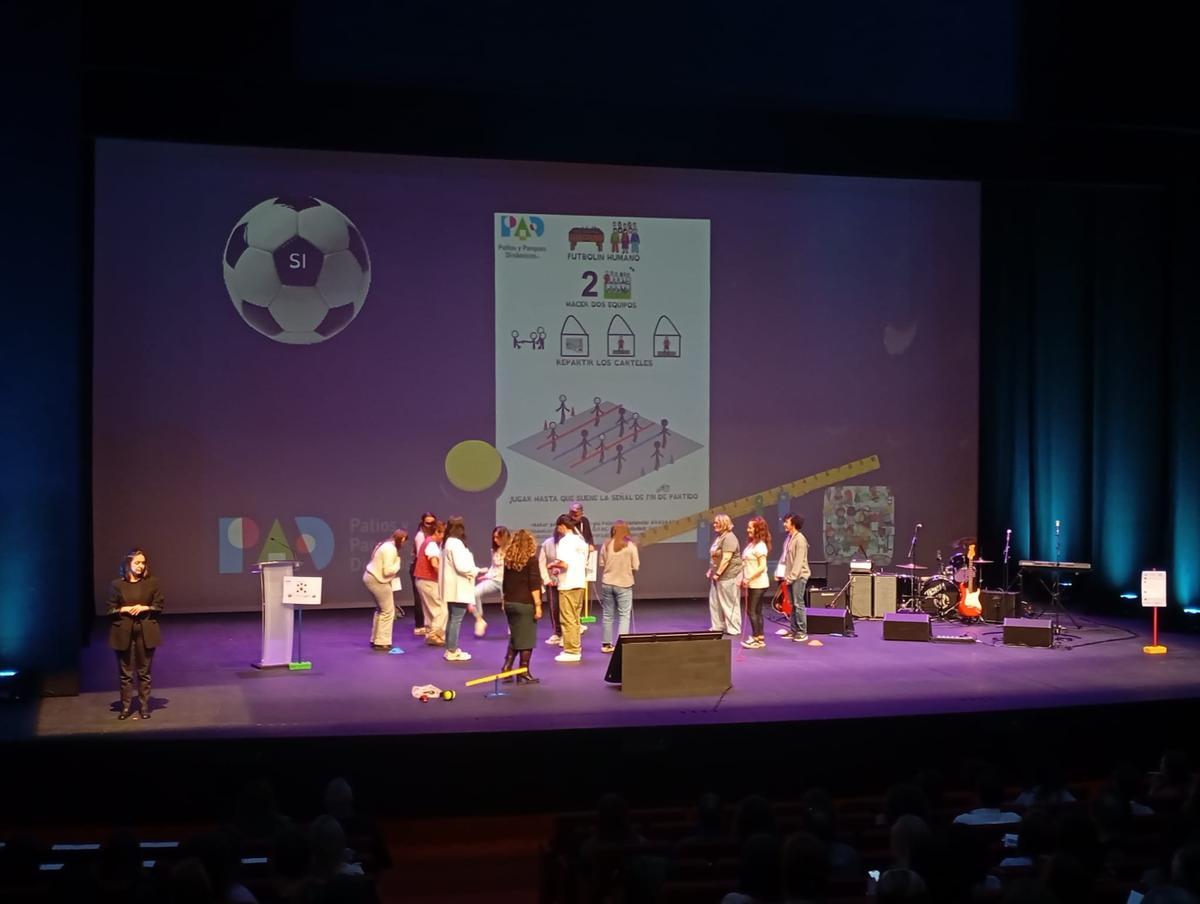 Varios docentes participan en un futbolín humano en el escenario del Niemeyer.