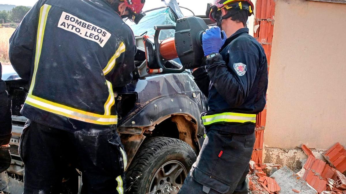 Los bomberos trabajan para excarcelar al hombre atrapado en su vehículo.