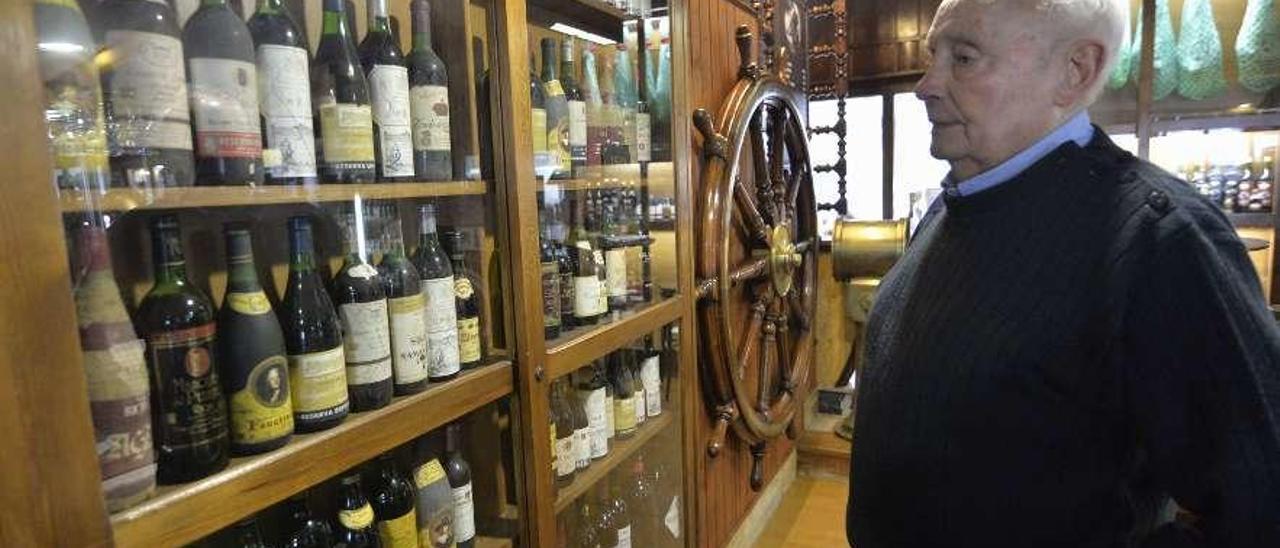 Arsenio Fernández, &quot;Tito&quot;, contempla la colección de botellas de vino que expone en la cantina.