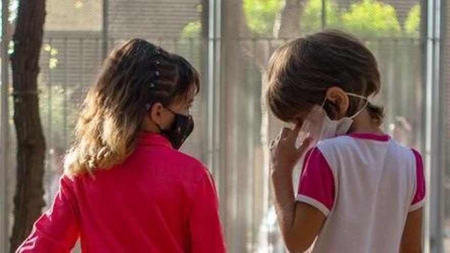 Dos niñas con mascarillas en el patio de un colegio, en imagen de archivo.