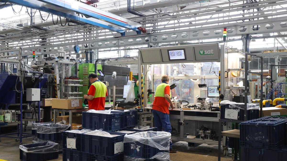 Dos operarios desarrollan su trabajo en una fábrica.