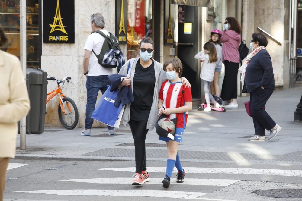 Gente con mascarilla y sin ella por el centro de Gijón.