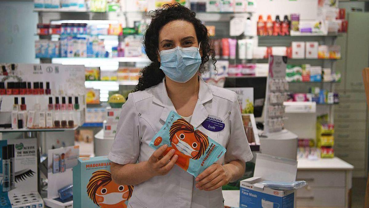 La farmacéutica Blanca González, con mascarillas infantiles, en su farmacia.