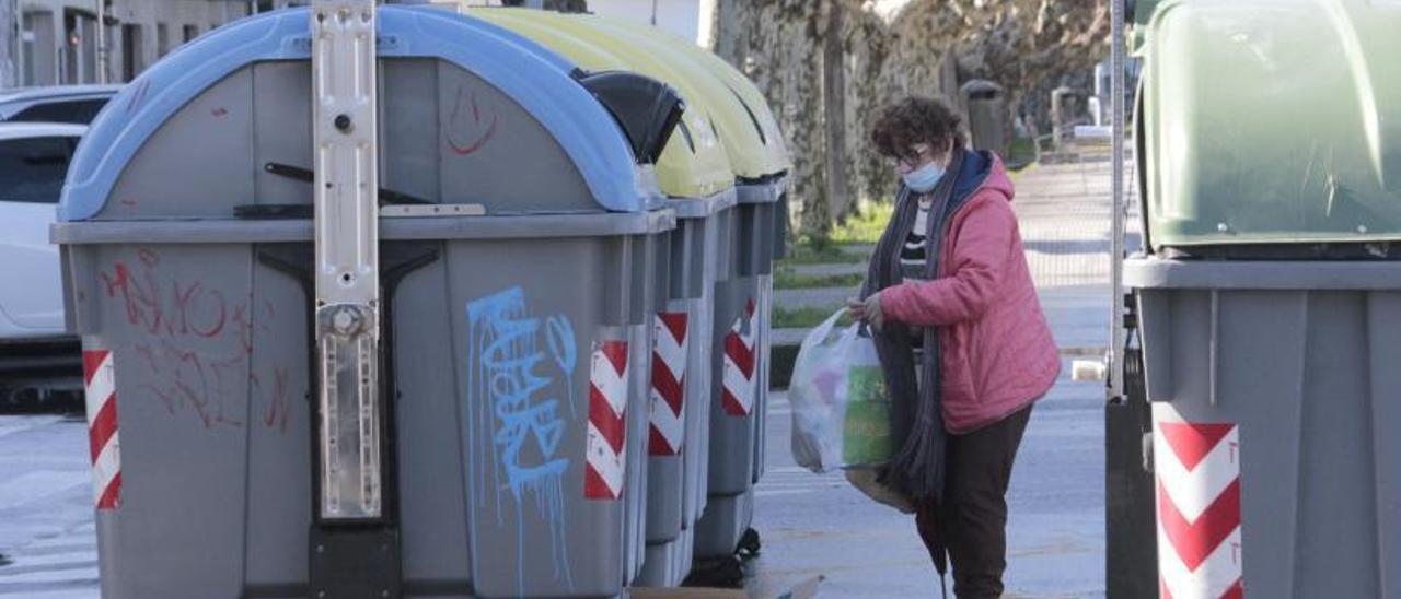 Una vecina de Bueu deposita ayer residuos, de manera separada, en los contenedores de reciclaje. |   // S.Á.