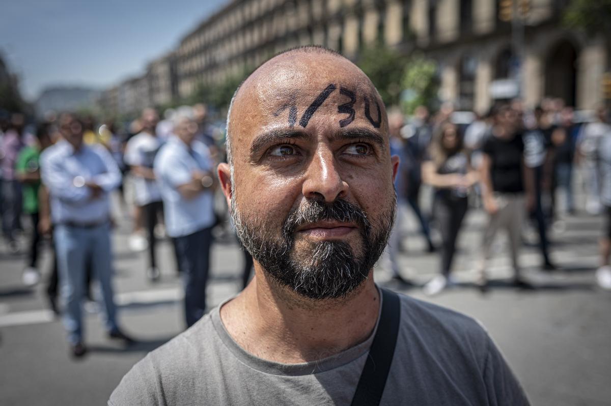 Un taxista luce la proporción de una VTC por cada 30 taxis en la frente, durante la protesta de este miércoles en Barcelona