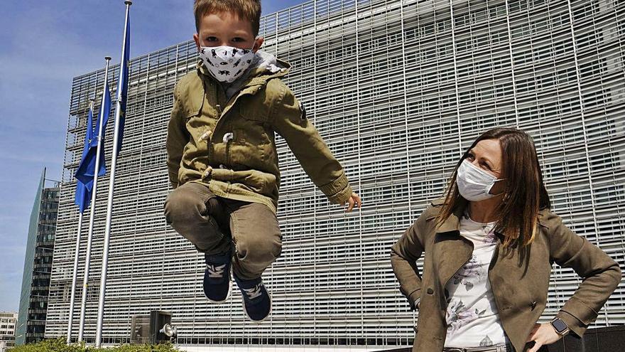 Un niño, junto a su madre, juega, ayer, frente a la sede de la Comisión Europea.