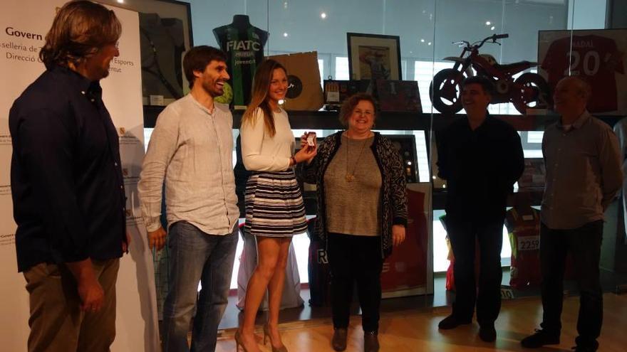 Melani Costa recibe la insignia de manos de la consellera Mateu, junto a Gonyalons y García.