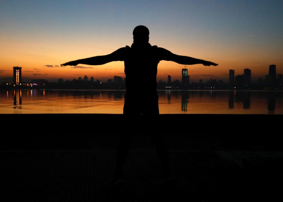 A man exercises early in the morning along the ...