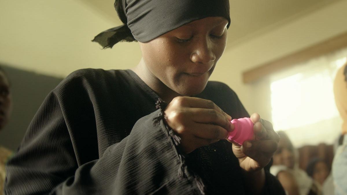 Mujer africana con copa menstrual en las manos