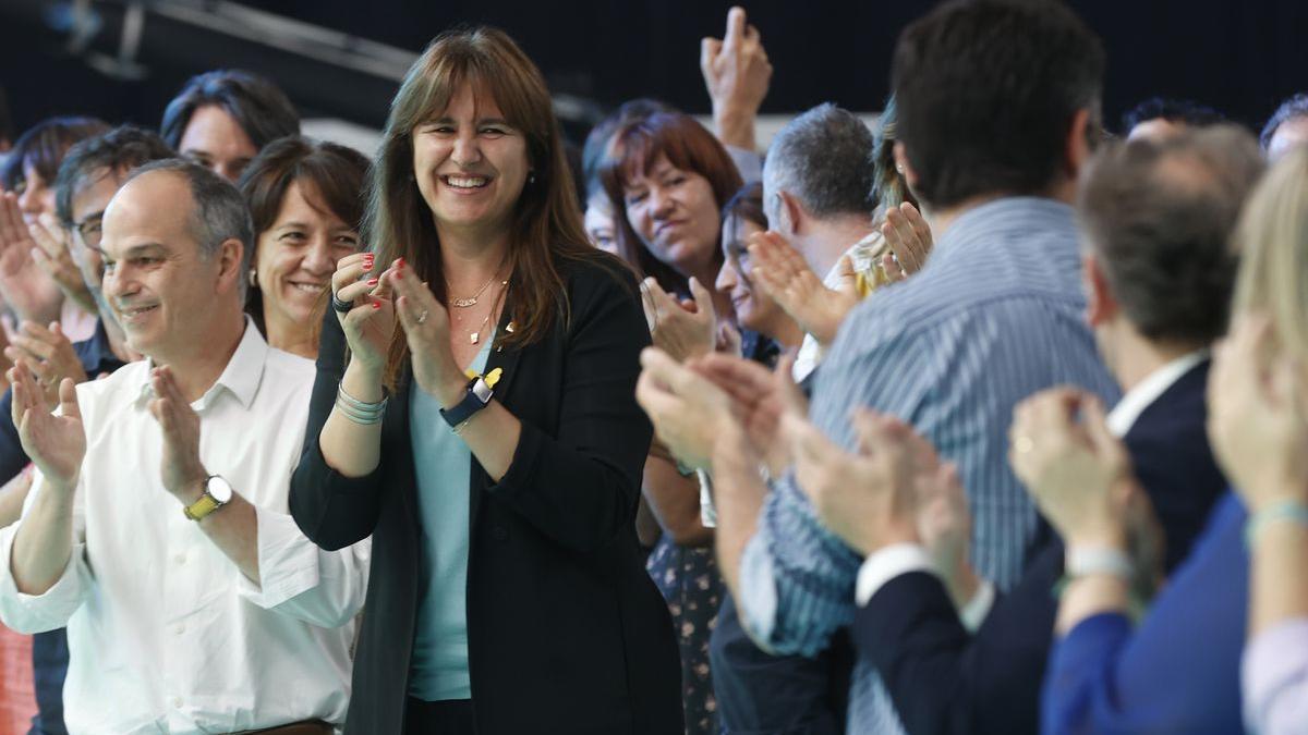 El secretario general de JxCat, Jordi Turull (i), y la presidenta del partido, Laura Borràs (c), aplauden durante la segunda jornada del congreso de la formación política este domingo en L’Hospitalet de Llobregat.