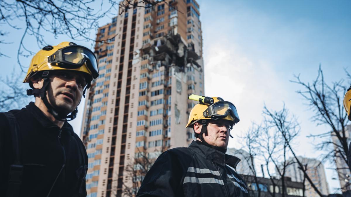 Bomberos, junto un edificio bombardeado en Kiev.