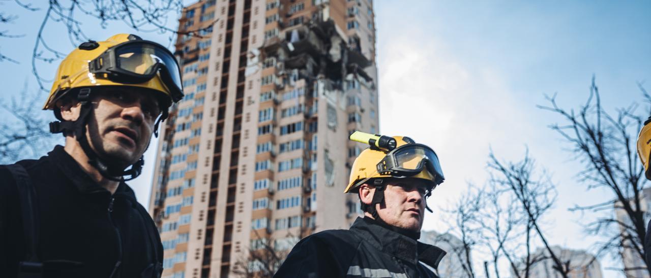 Bomberos, junto un edificio bombardeado en Kiev.