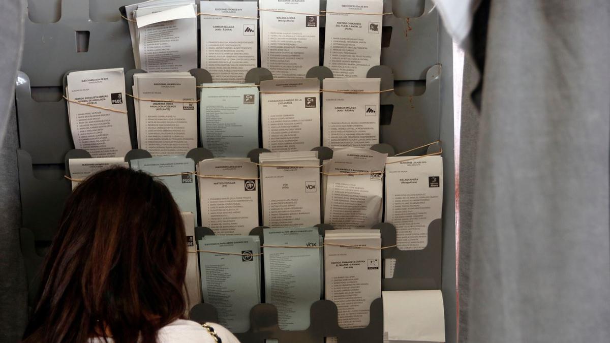 Una mujer busca su voto para los comicios municipales de 2019 en un colegio electoral malagueño.