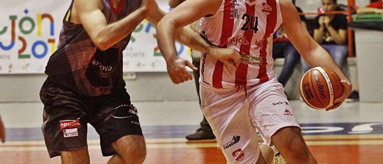 Jorge Escapa, con el balón, trata de superar a un rival en un partido con el Gijón Basket de la pasada temporada.