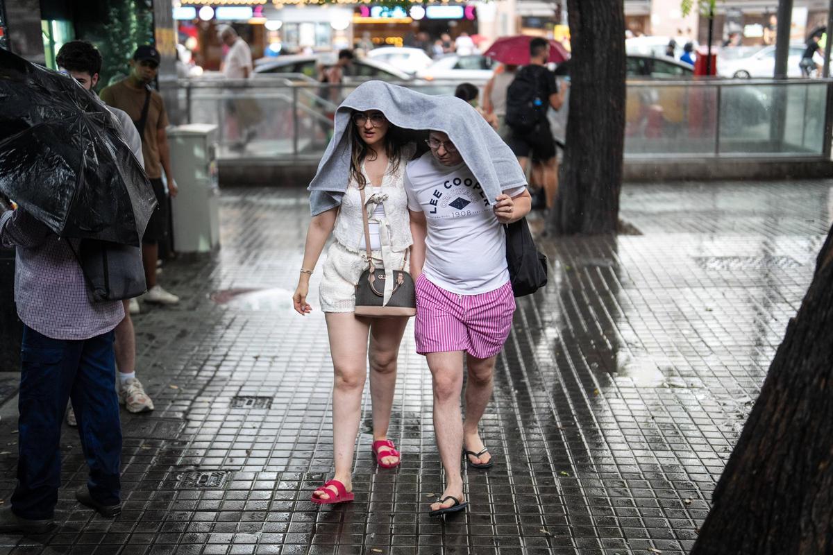 Dos personas se resguardan de la lluvia.Foto archivo