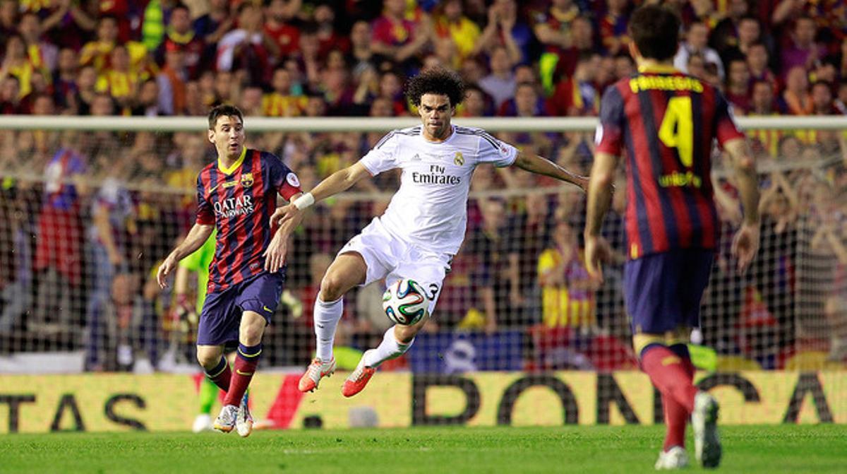 Pepe salta per controla la pilota davant de Messi i Cesc.