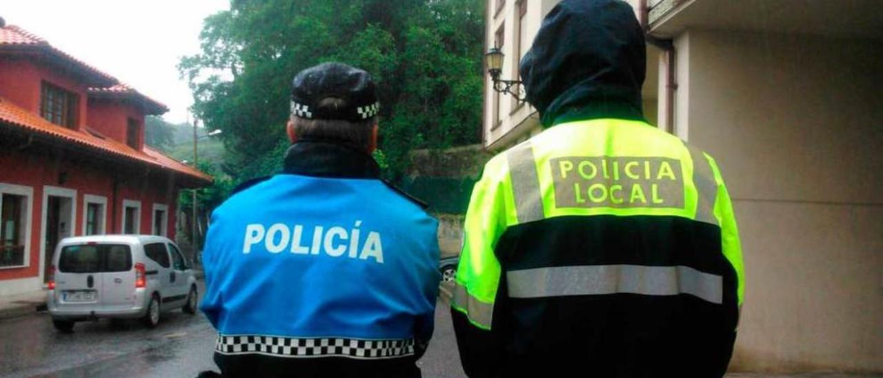 Dos policías llaniscos, con uniformes diferentes, uno de ellos &quot;rescatado&quot; tras haber sido retirado por su mal estado de conservación por su antigüedad.