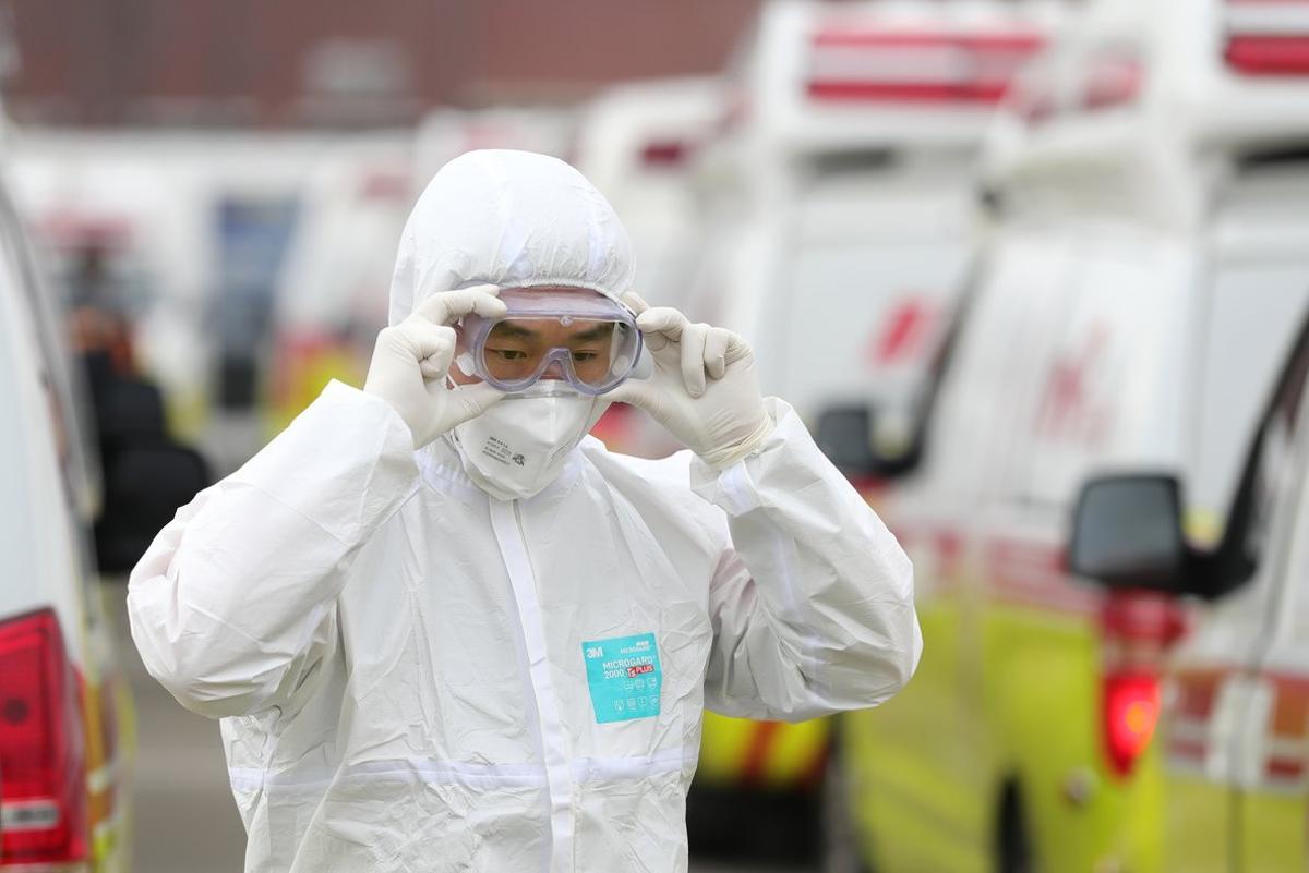 01 March 2020, South Korea, Daegu: A health worker checks his protective glasses before starting his work. Photo: -/YNA/dpa