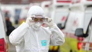 01 March 2020, South Korea, Daegu: A health worker checks his protective glasses before starting his work. Photo: -/YNA/dpa